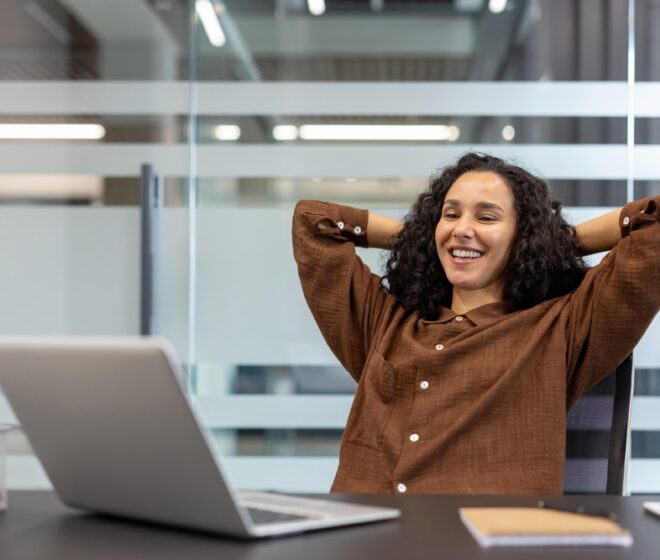 A,Relaxed,Woman,Smiles,,Leaning,Back,In,Her,Office,Chair