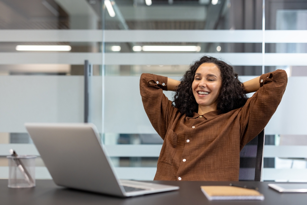 A,Relaxed,Woman,Smiles,,Leaning,Back,In,Her,Office,Chair